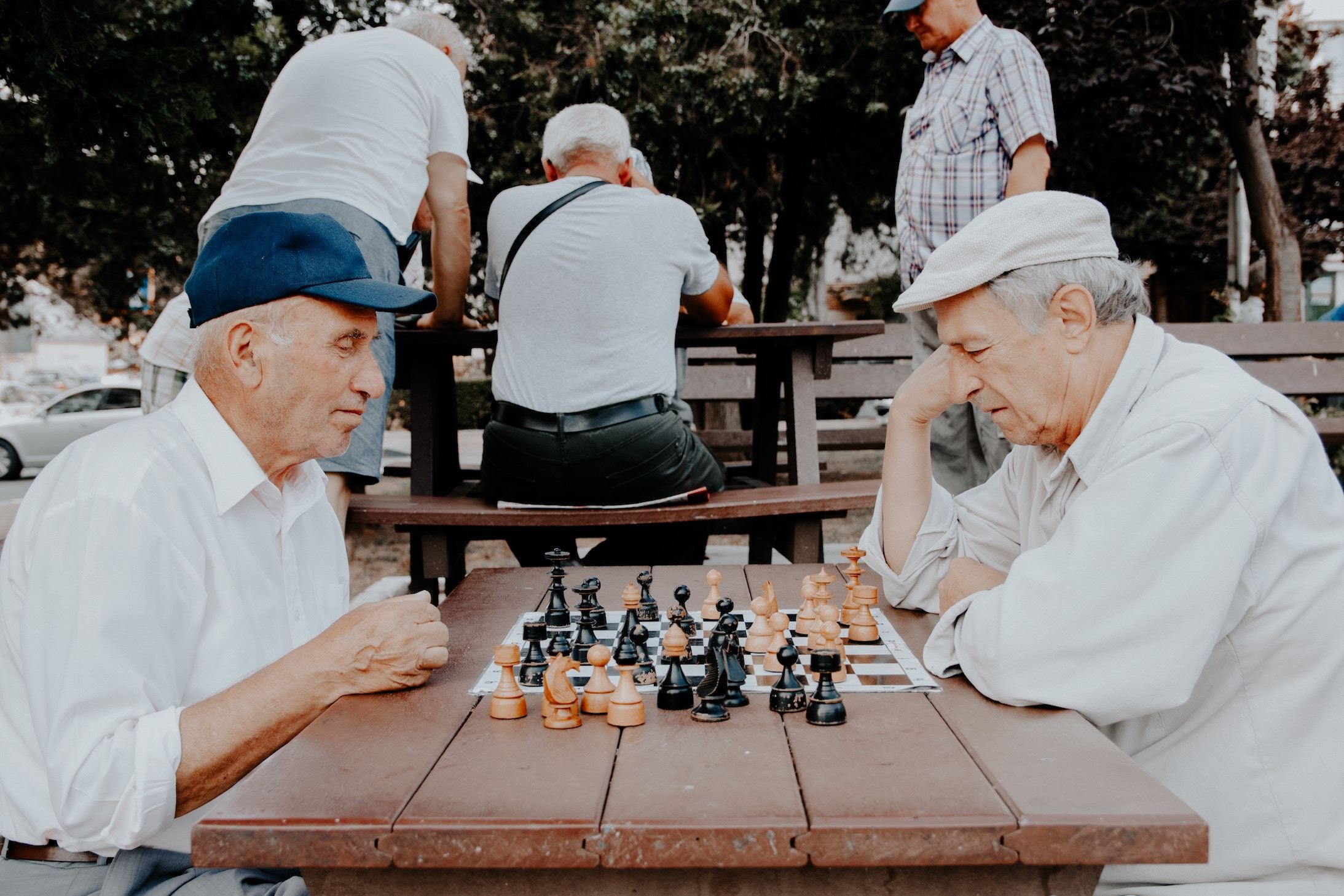 Two elderly men playing chess in a park